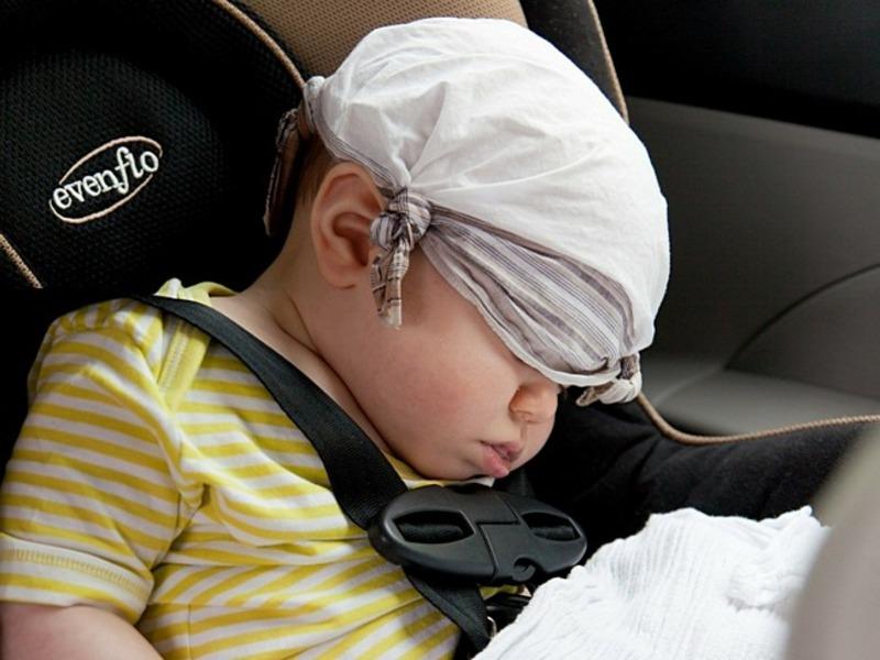 Грудничок спит в машине с платочком на голове